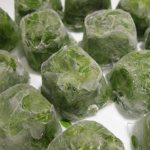 Frozen cubes of shredded green lettuce with water from the freezer